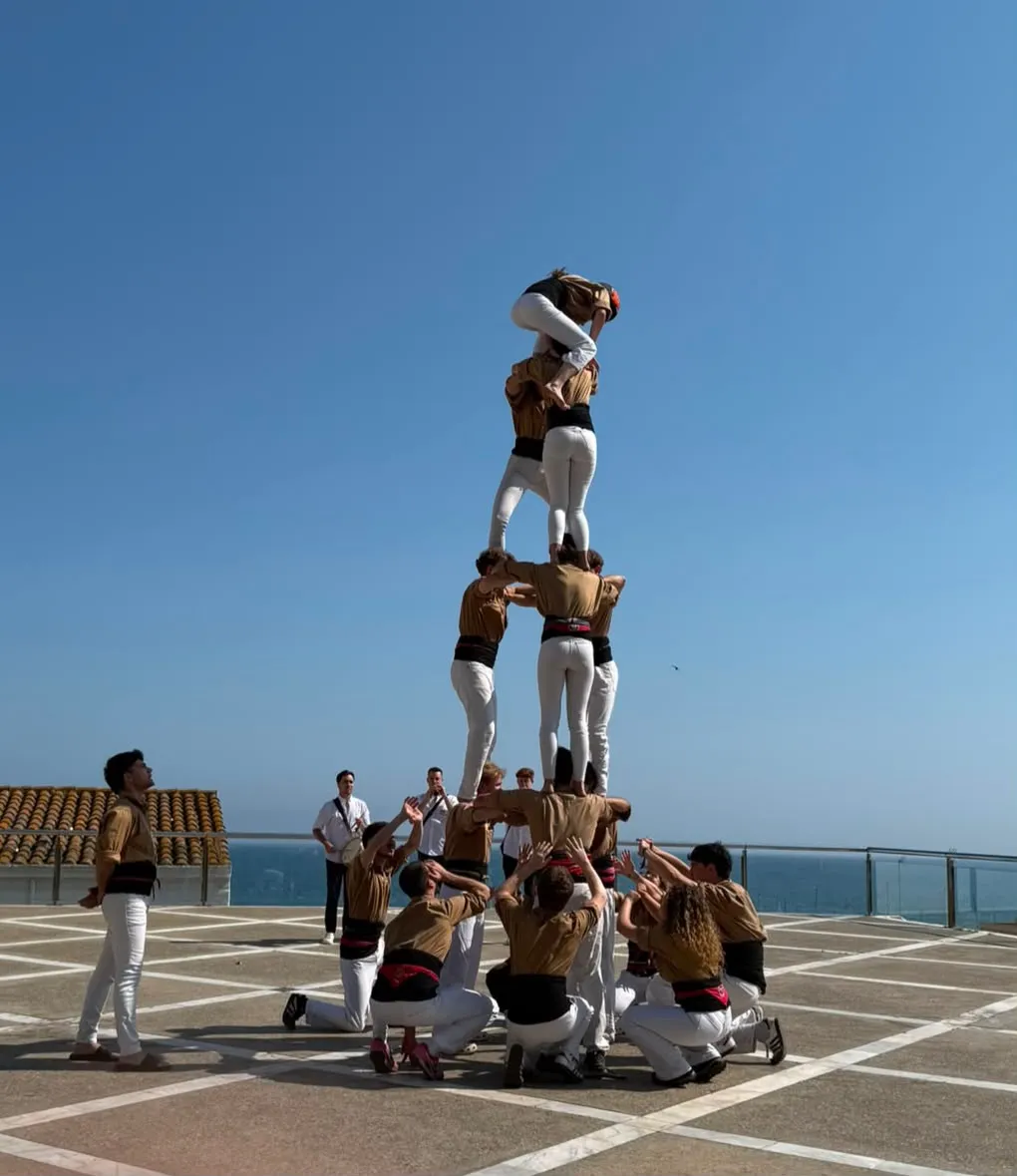 Castellers aixecant un castell a la terrassa d’un casament vora el mar