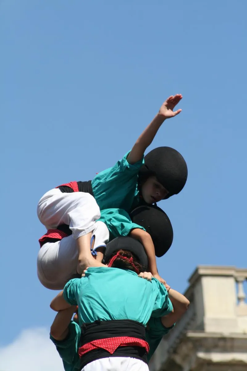 Enxaneta fent l'aleta al cim d'un castell, el moment culminant de la construcció