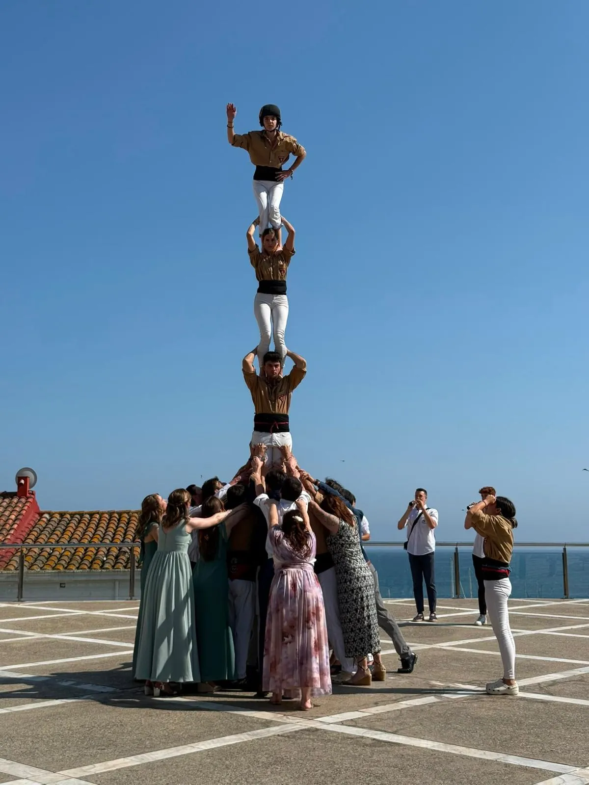 Convidats d’un casament fent pinya sota un pilar de castellers