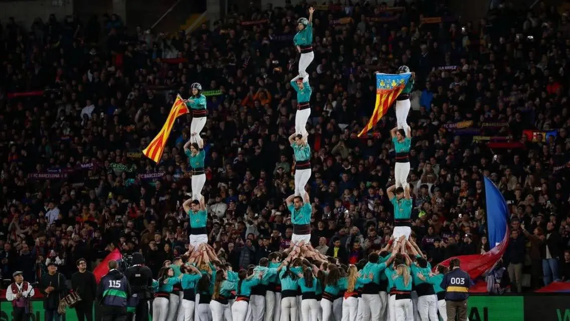 Pilars castellers amb banderes en un estadi