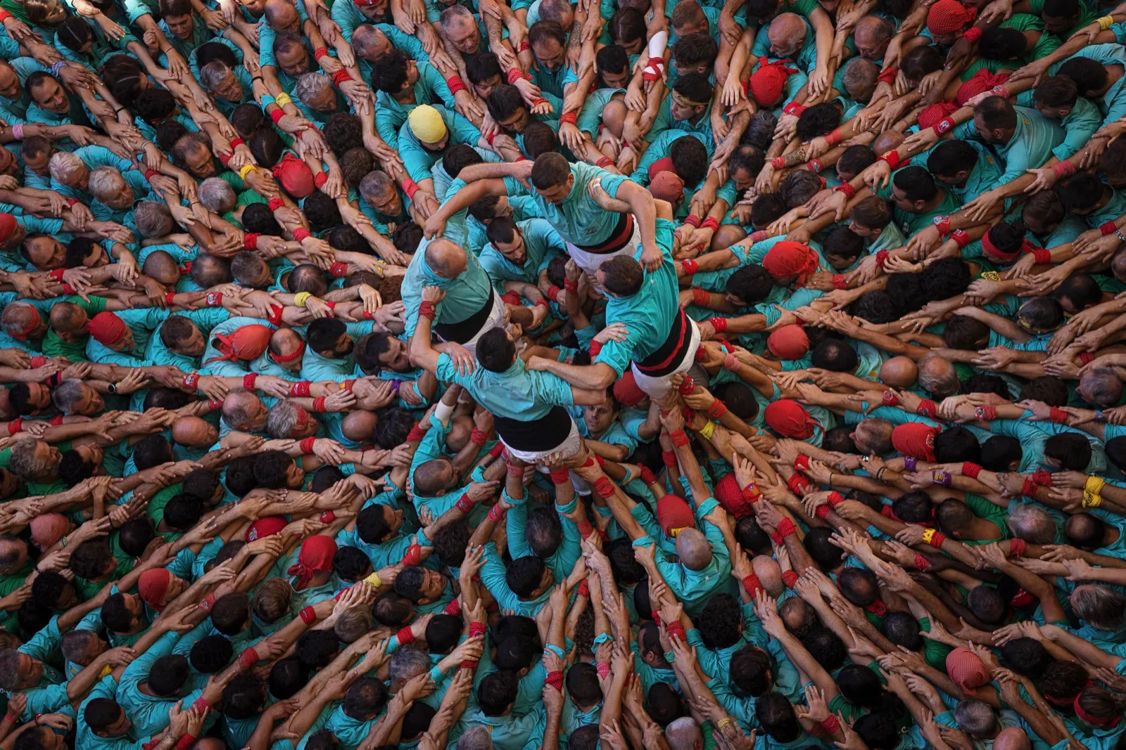 Detall de la pinya d'un castell: desenes de persones abraçades formant la base